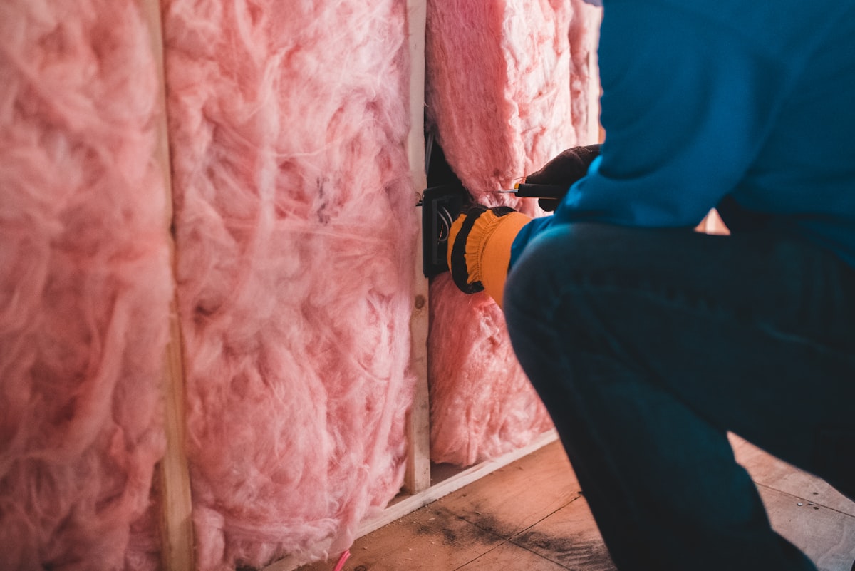 Ouvrier posant des panneaux isolants en laine de bois sur un mur intérieur